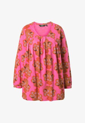 Blouse rose à manches longues avec des motifs floraux orange et rouges, col rond et plis sous le col.