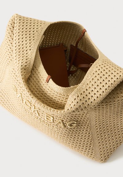 Sac fourre-tout OACKBAG beige texturé avec ouverture sur le dessus révélant un portefeuille en cuir marron et un porte-cartes à l'intérieur.