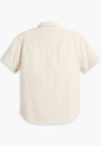 Short-sleeve, collared shirt in off-white, featuring a smooth texture, curved hem, and lightly structured back yoke seam detail.