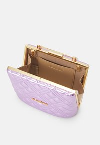 Lila päällystetty käsilaukku metallinhohtoisella kultakehyksellä, jossa on sileä sisustus ja merkkilappu. Auki ylhäältä helppoa pääsyä varten.