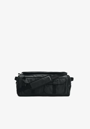 Zwarte rechthoekige crossbodytas met twee voorvakken met rits, verstelbare gewatteerde schouderband en een klein logopatch op een van de vakken.