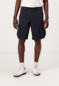 Bermudas de cargo navy avec poches latérales, fabriquées en coton résistant. Présente un design à jambes droites et une taille régulière.