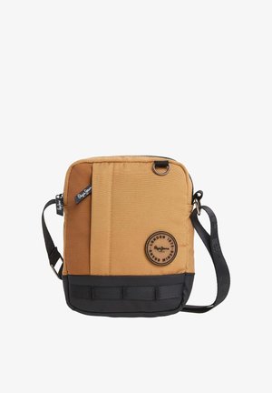 Bolsa mensajera marrón con fondo negro, textura de tela, correa ajustable, cierre de cremallera, parche con logo y bolsillo frontal con un acento a rayas.