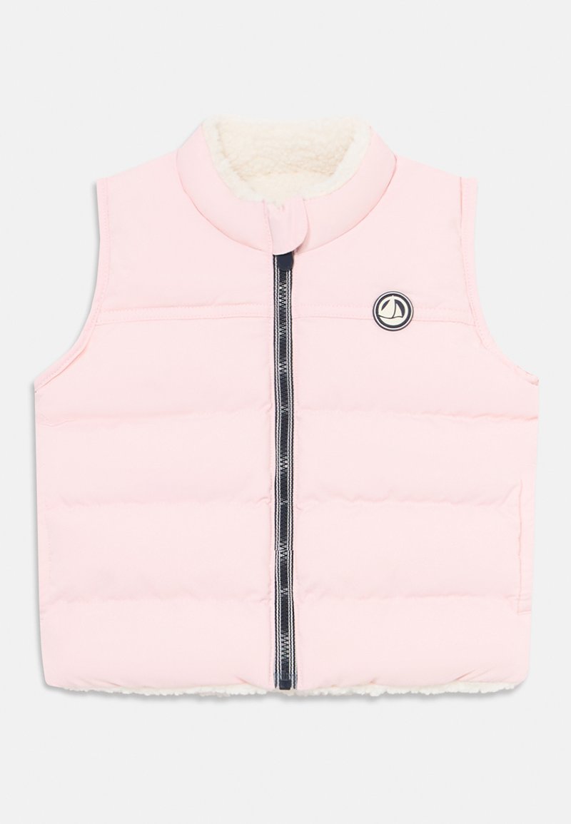 Lys rosa ermeløs polstret vest med frontglidelås og hvit fleecefôr, med en liten rund logo med en seilbåt på brystet.