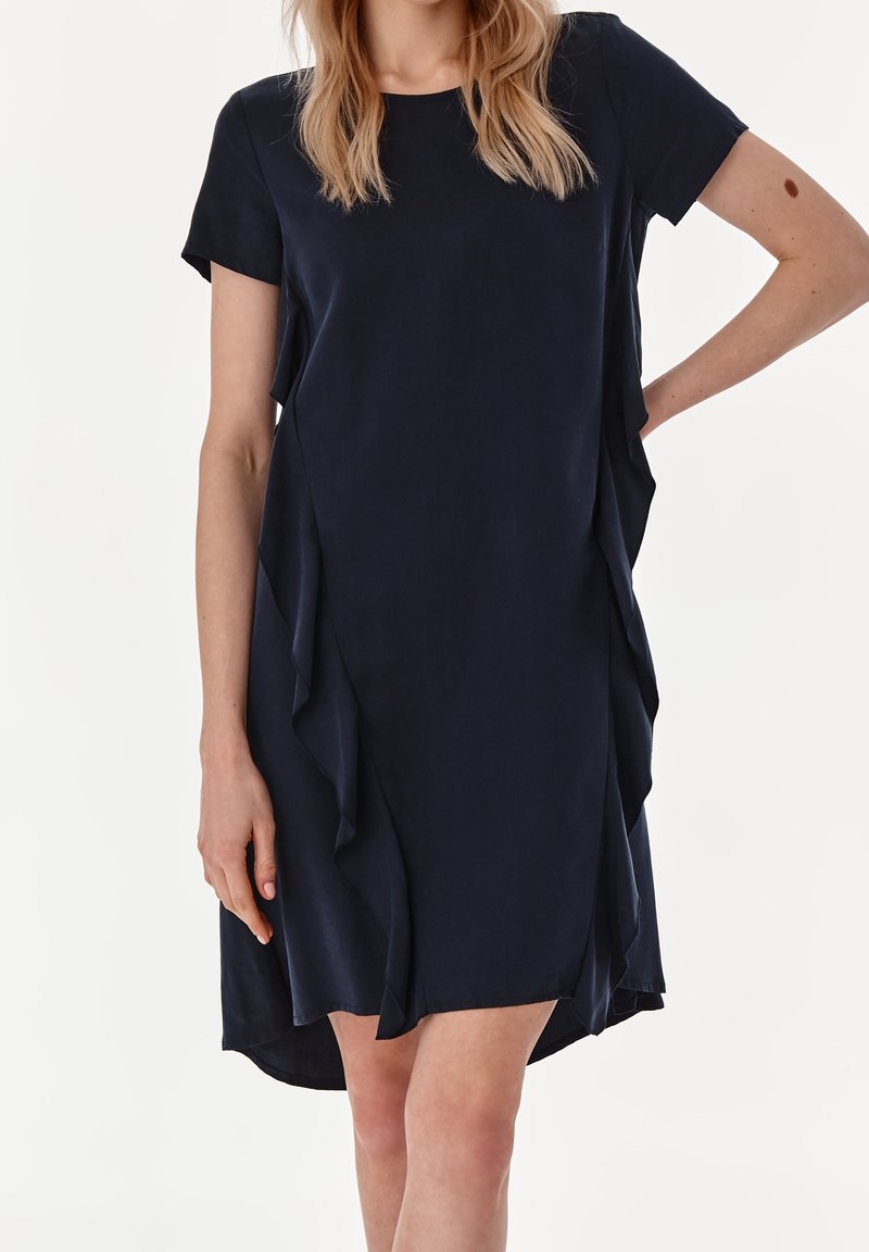 Kaiserblaues, kurzärmeliges Kleid mit lockerer Passform. Verfügt über asymmetrische Rüschendetails an den Seiten und einen abgerundeten Saum. Glatte Textur.