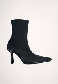 Černé kotníkové boty vyrobené z hladké tkaniny s špičatou špičkou, vysokým stiletto podpatkem a bezešvým designem. Vyznačují se minimalistikou siluetou.
