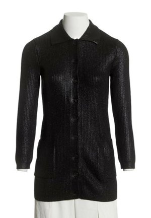 Long cardigan noir en maille avec des boutons sur le devant, deux poches avant, manches longues et col sur un mannequin blanc.