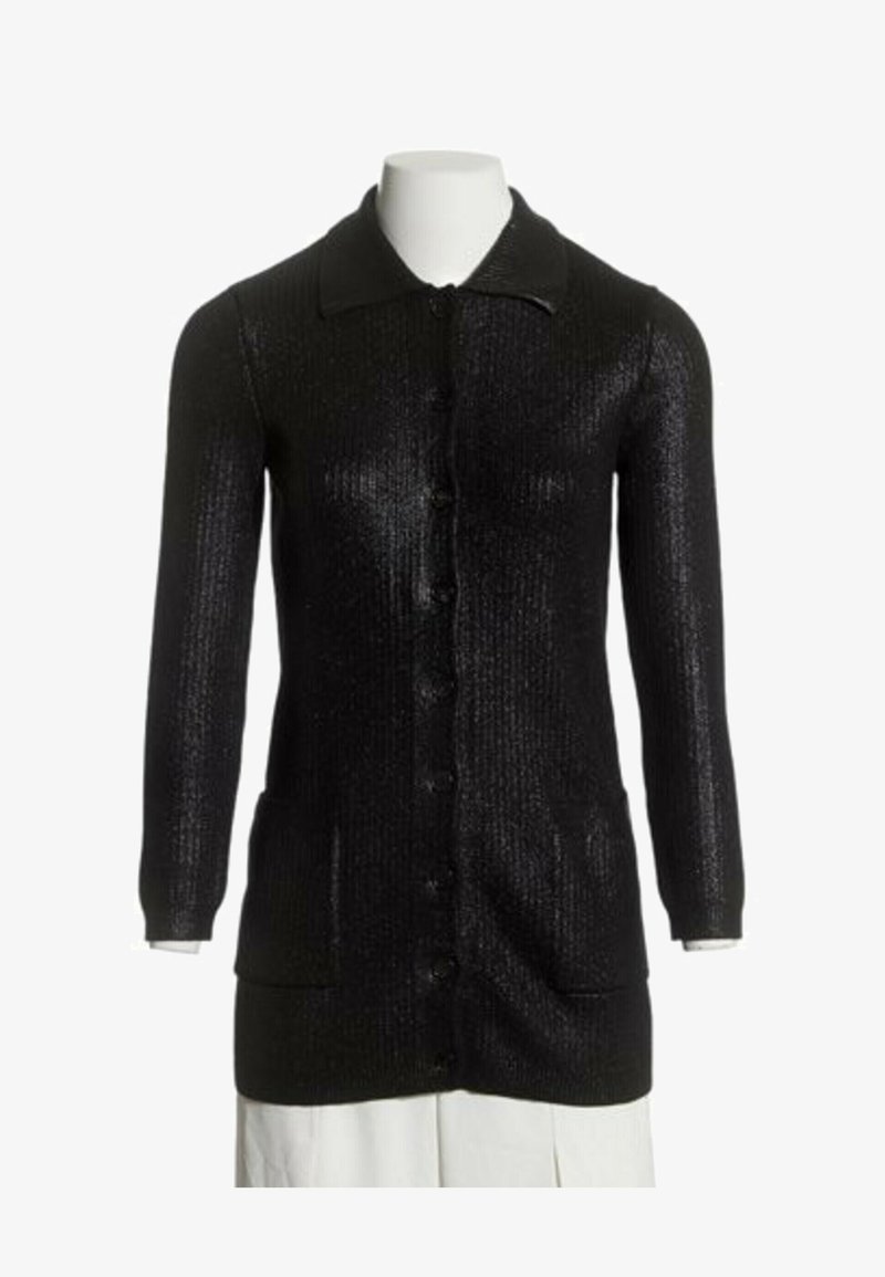 Long cardigan noir en maille avec des boutons sur le devant, deux poches avant, manches longues et col sur un mannequin blanc.