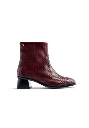 Bottine bordeaux avec une texture tissée et un talon bloc. Présente un bout arrondi et un accent doré près de la cheville.
