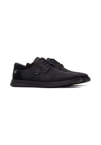Zapatos de ante negros con un perfil bajo, punta redonda, diseño de cordones, costuras distintivas y una suela de goma flexible.
