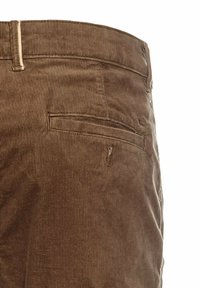 Gros plan sur un pantalon en velours côtelé marron montrant les détails de la poche arrière et des passants de ceinture du côté droit.