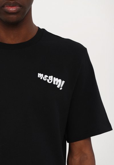 Camiseta de algodón negra con un logo bordado en blanco "msgm!" en el lado izquierdo del pecho. Manga corta y cuello redondo.
