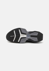 Semelle de sneaker noire et grise présentant un design texturé avec un profil de semelle à motifs et des accents blancs ; inclut le logo "Continental".