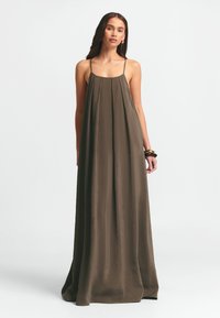 Maxiklänning i olivgrön, tillverkad av lättviktig fabrik. Har tunna band, en lös passform och subtila veck för textur och flöde.