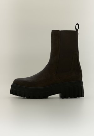 Schwarzer Knöchelstiefel mit grober Profilsohle, rundem Zehenbereich, elastischen Seitenteilen und Zuglasche hinten, von der Außenseite gezeigt.