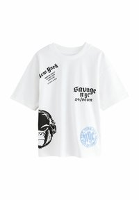 Vitt kortärmad t-shirt med svarta grafiska tryck av en gorilla och texten "New York" samt "Savage NYC 24/7", med blå cirkulär logotyp som accent.