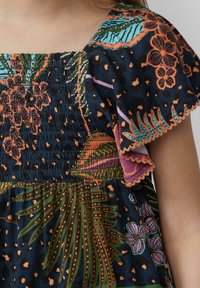 Bloemendess met een smock-bustier en korte fladdermouwen. Donkerblauwe stof met oranje, groene, roze en paarse accenten.