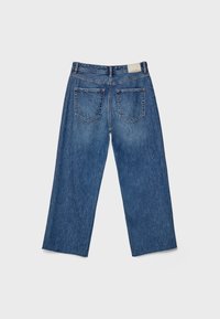 Blå denimjeans med rak ben-design, två bakfickor, urvikt textur och fransig nederkant. Etikett synlig vid midjan.