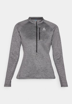 Gray long-sleeve athletic mid-layer top with a high collar, half-zip front, and a small chest pocket. Features textured fabric and logo detail.