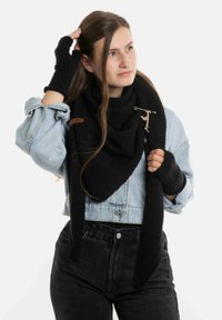 Zwarte gebreide sjaal met textuur, om de nek gedrapeerd, gecombineerd met vingerloze handschoenen. Bevat een decoratieve broche en leren accent.