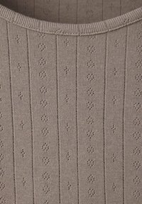 Gros plan sur un tissu tricoté beige avec des côtes verticales et de petits motifs ajourés en forme de losange.