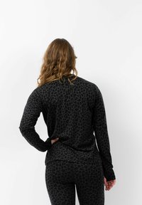 Schwarz mit Leopardenmuster bedrucktes Langarmoberteil und Leggings, aus weichem, strukturiertem Stoff gefertigt, mit passgenauem Design und bequemer Bauweise.
