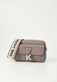 Graue Umhängetasche aus Kunstleder mit dreieckiger Klappe, silberner Hardware und einem Riemen mit der Aufschrift "KARL LAGERFELD". Auffälliges K-Anhänger-Detail.