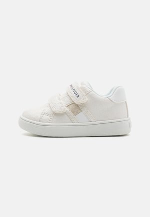 Baskets blanches pour enfants avec des sangles Velcro, dessus texturé et semelle en caoutchouc. Présente un logo sur le côté et un doublure intérieure douce.