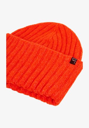 Gebreide oranje beanie met ribbeltextuur en een omgeslagen boord, voorzien van een klein zwart etiket met de tekst "protest".