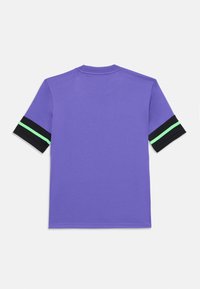 Violeta īsām piedurknēm krekls ar melniem piedurkņu maliņām, uz kurām redzama šaura neona zaļa līnija, attēlots no aizmugures uz baltas fona.