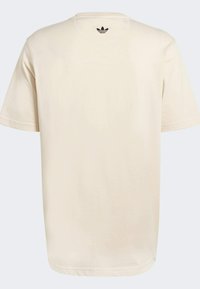 Svijetlosmeđa pamučna majica kratkih rukava, s okruglim izrezom i malim crnim Adidas trefoilm logotipom pozadi blizu ovratnika.