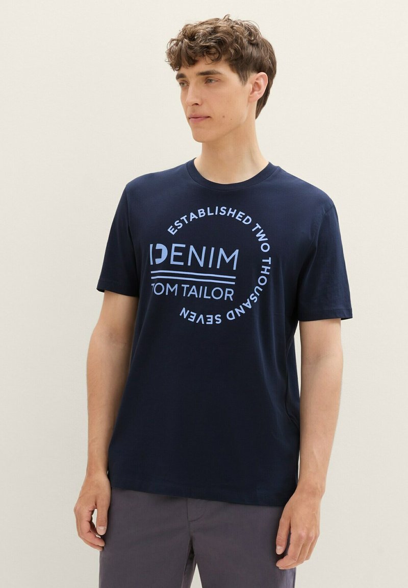 Námořnická modrá bavlněná tričko s kulatým grafickým potiskem s textem "DENIM" a "TOM TAILOR" v světlé modré. Krátké rukávy a design s kulatým výstřihem.