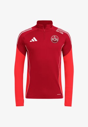 Czerwony sportowy top treningowy z długim rękawem, ćwierćzamkiem, białym logo adidas, emblematem klubu 1. FCN i białymi paskami na ramionach.