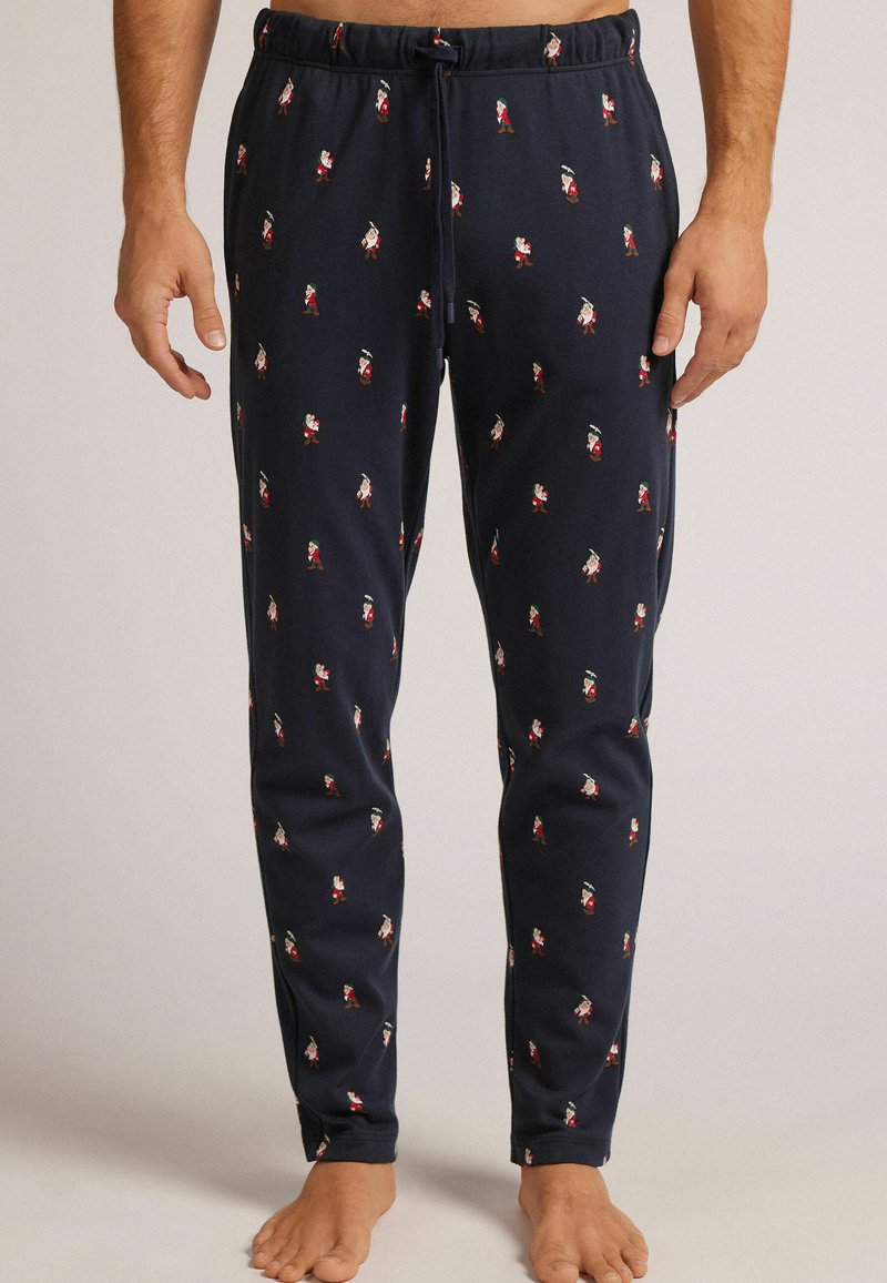 Pantalones de pijama azul marino hechos de una tela suave, con un patrón de pequeñas figuras de estilo caricaturesco. Cintura elástica con detalle de cordón.