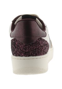 Sneaker bianco con un tallone borgogna testurizzato e accenti scintillanti. La suola è in gomma bianca con una superficie di presa a motivi. Lacci piatti sopra.