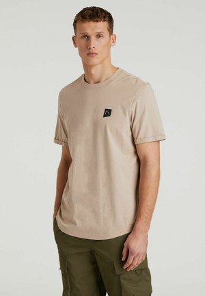 Beige Baumwoll-T-Shirt mit kurzen Ärmeln, Rundhalsausschnitt und einem kleinen schwarzen Logopatch auf der linken Brust. Glatte Textur und lässige Passform.