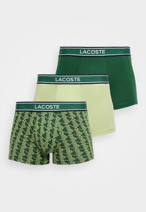 Tre paia di boxer Lacoste: verde scuro tinta unita, verde chiaro e verde fantasia con motivi geometrici gialli. Cinturini elastici.
