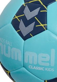 Blå och marinblå fotboll med gula accenter. Har en strukturerad yta, hexagonala paneler och tryckt logotyp "Numel Classic Kids."