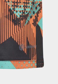 Wzorzysta tkanina sportowa w kolorze pomarańczowym, czarnym i turkusowym. Posiada geometryczne wzory z kropkami i paskami oraz teksturowane wykończenie. Zawiera logo "AEROREADY".