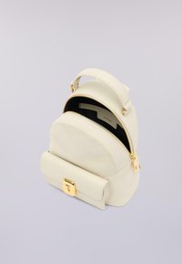 Mochila beige claro texturizada hecha de material sintético, con un diseño curvado, un cierre dorado y un bolsillo frontal con un broche dorado.