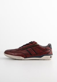 Sneaker rossa in pelle con accenti perforati, strisce navy a contrasto e cerniera laterale. Presenta una suola in gomma per una migliore aderenza.