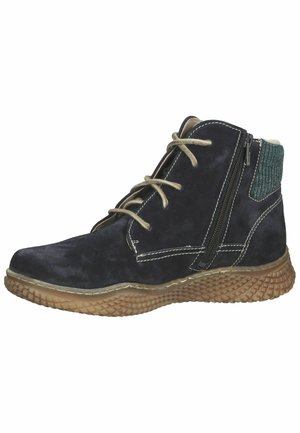 Navy suede ankle boots with olive green fabric accent, lightweight rubber sole, dual zippers, and contrasting white stitching details.