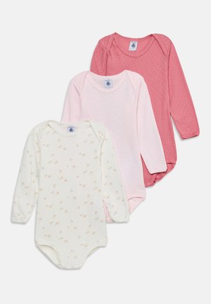 Tre langærmede babybodysuit i creme med blomstertryk, lys pink og mørk pink, lagt overlappende på en hvid baggrund.