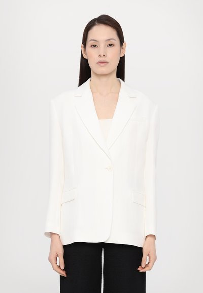 White tailored blazer with a single button, notched lapels, and patch pockets. Textured fabric with a smooth finish.