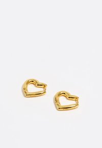 Pendientes de oro en forma de corazón con un acabado pulido y un diseño de cierre. Grabados con el nombre de la marca "BIMBA Y LOLA."