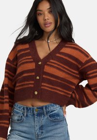 Gekürzter, gestreifter Cardigan in Rost- und Orangetönen, mit tiefem V-Ausschnitt und vier Messingknopfverschlüssen vorne. Weicher Stoff.
