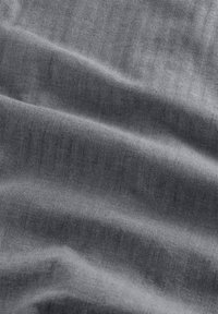 Gray herringbone fabric featuring a soft texture with subtle sheen, displaying gentle waves and a refined pattern throughout.