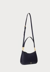Marineblaue Leder-Crossbody-Tasche mit einer geschwungenen Form, verstellbarem Tragegurt, goldenen Beschlägen und einem Reißverschlussverschluss, der ein geprägtes Logodesign aufweist.