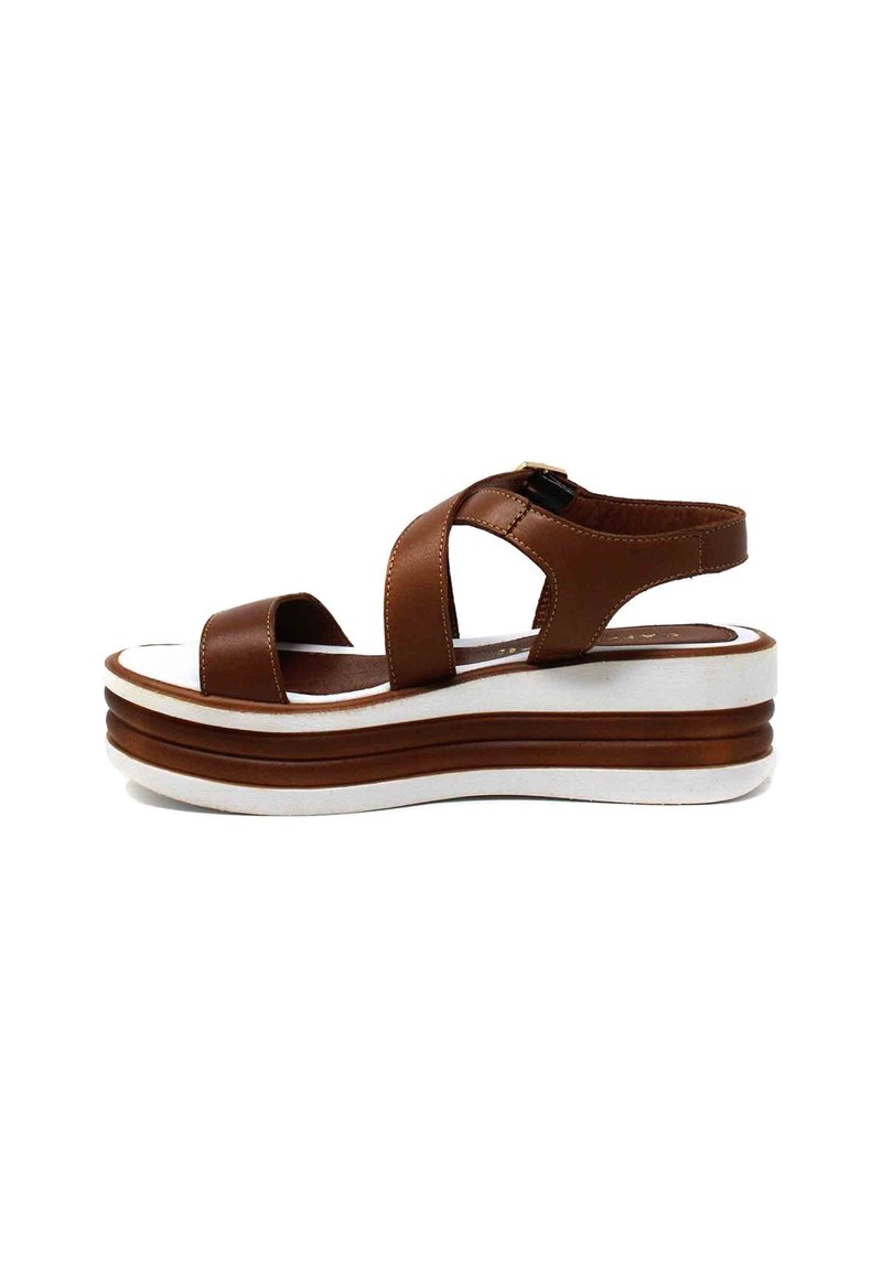 Sandalo con zeppa in pelle marrone, con punta aperta, cinturini incrociati e suola piattaforma bianca con strisce marroni. Chiusura con fibbia regolabile.