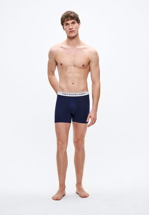Temno modri boksarji z belim elastičnim pasom, na katerem je napis "POLO RALPH LAUREN". Mehka, gladka tkanina z oprijetim krojem.